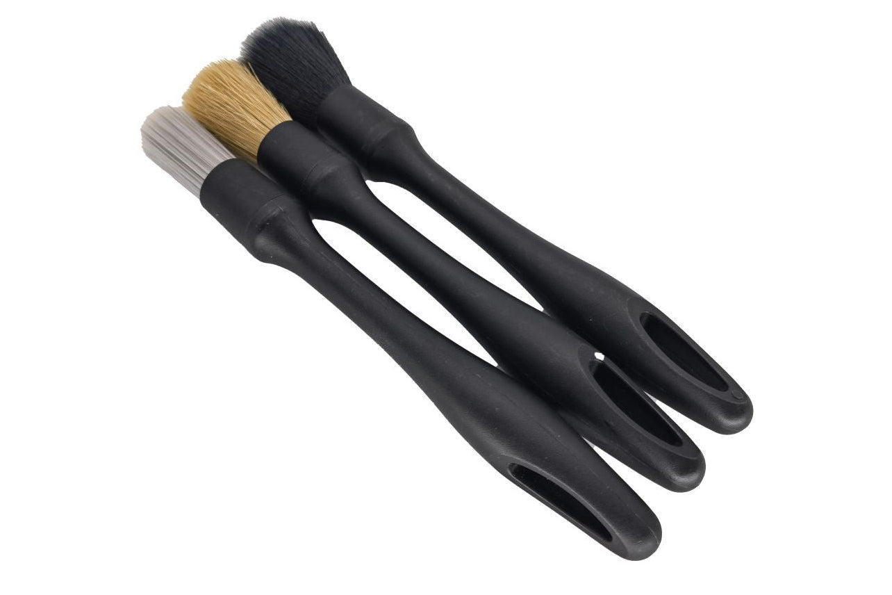 Set of three black brushes with different bristle types on a white background