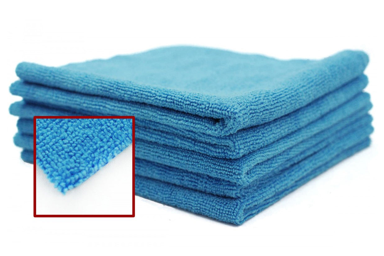 Stack of blue microfiber cloths with a close-up of the texture on a white background
