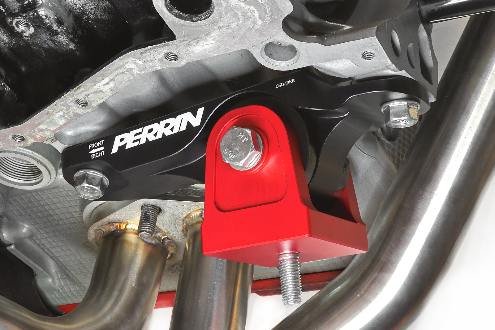 PERRIN Engine Mounts in black billet aluminum with red anodized mounting bases and black bushings installed on a Subaru.
