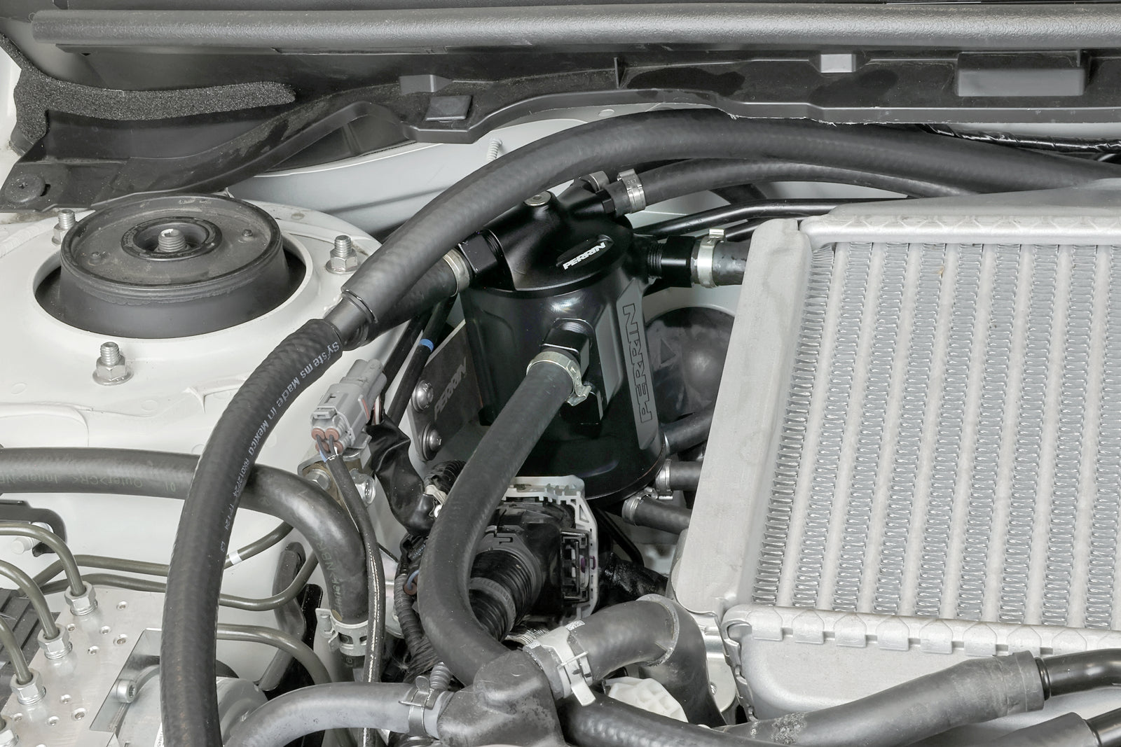PERRIN black Air Oil Separator installed in 2002-2021 Subaru WRX/STI engine bay.