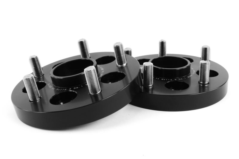 Black Subaru wheel adapters converting 5x100 to 5x114.3 bolt patterns, featuring multiple threaded holes for installation.