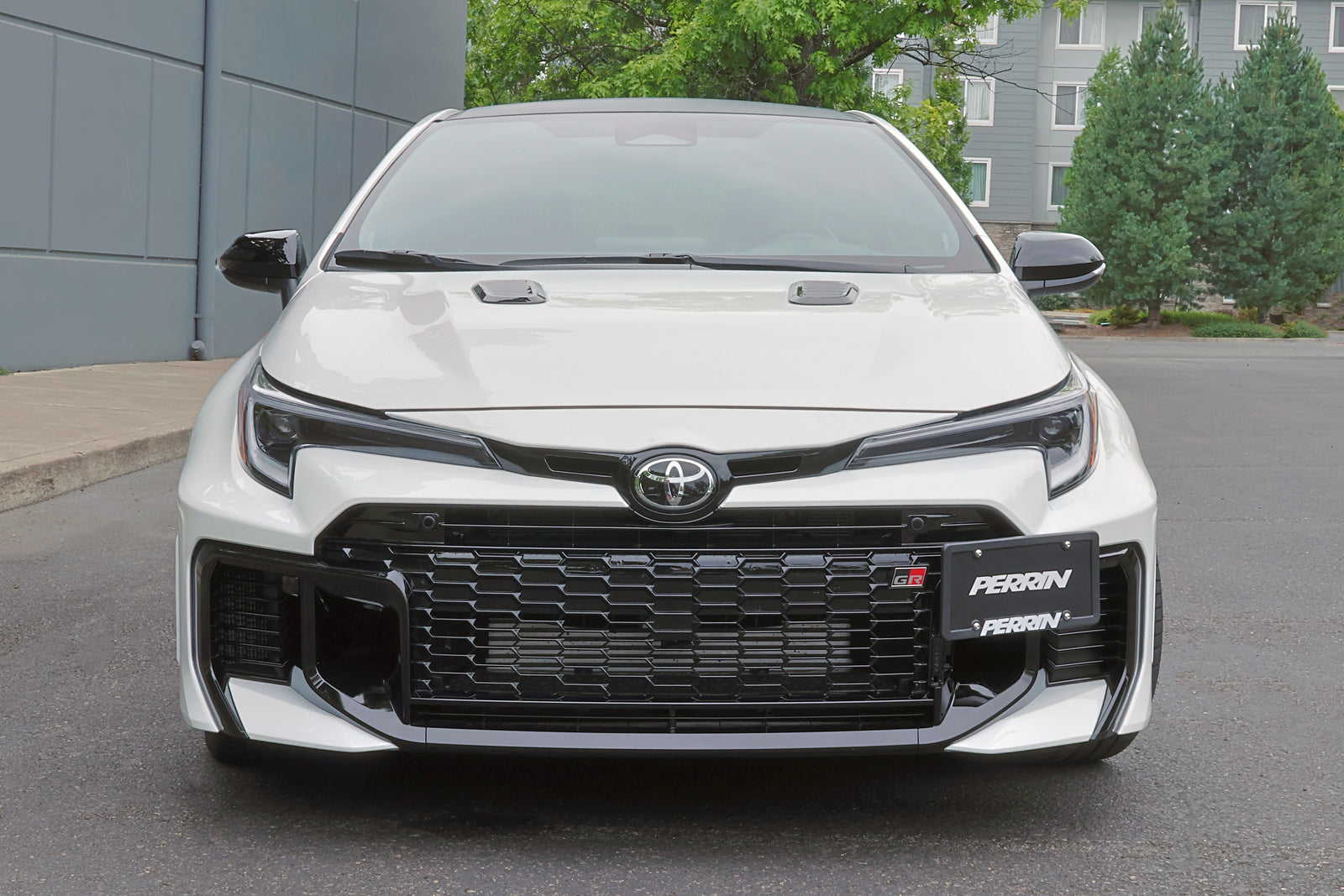 PERRIN license plate relocation bracket installed on GR Corolla front bumper showing mounting location.