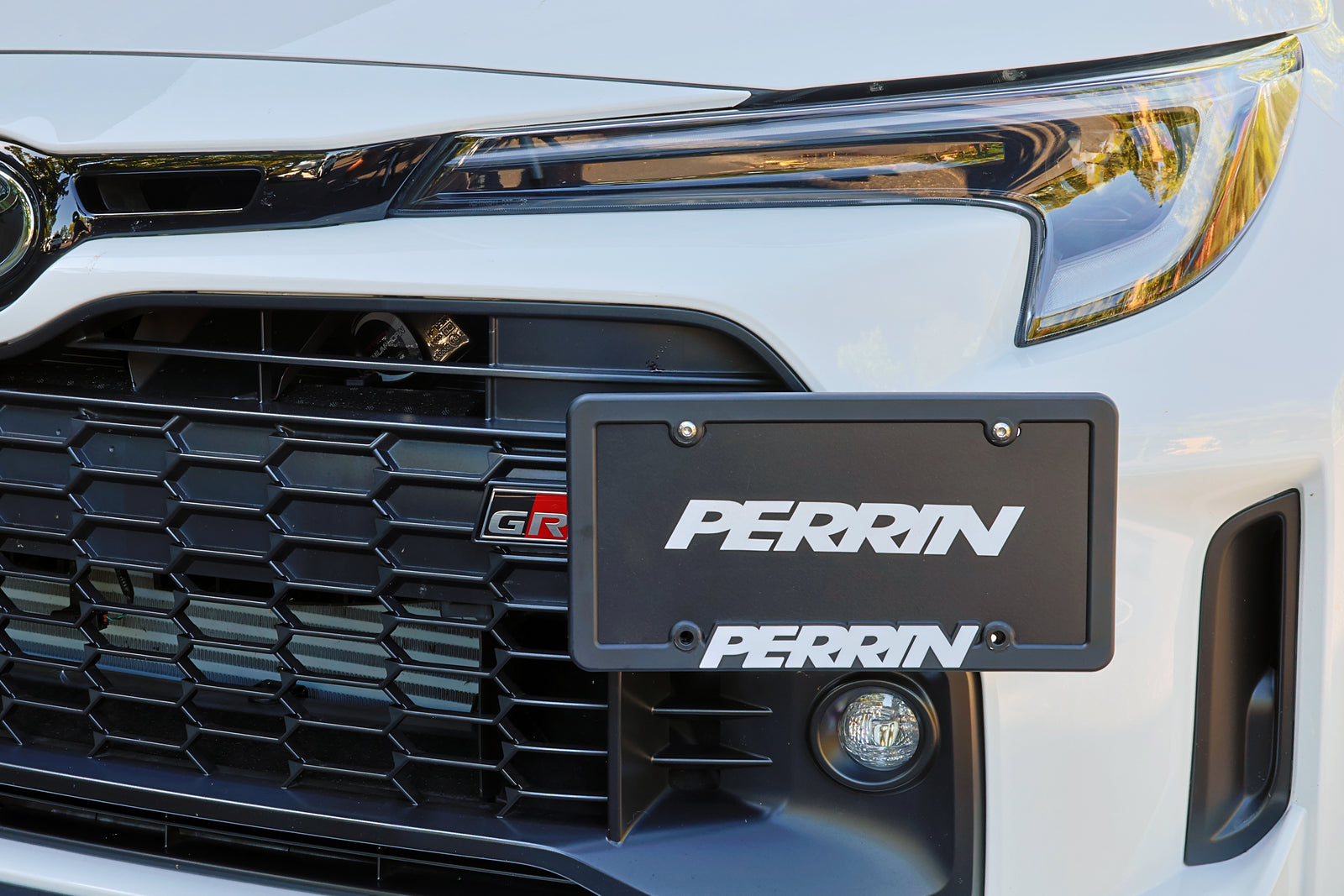PERRIN License Plate Relocation bracket assembly with aluminum frame and mounting hardware for GR Corolla."