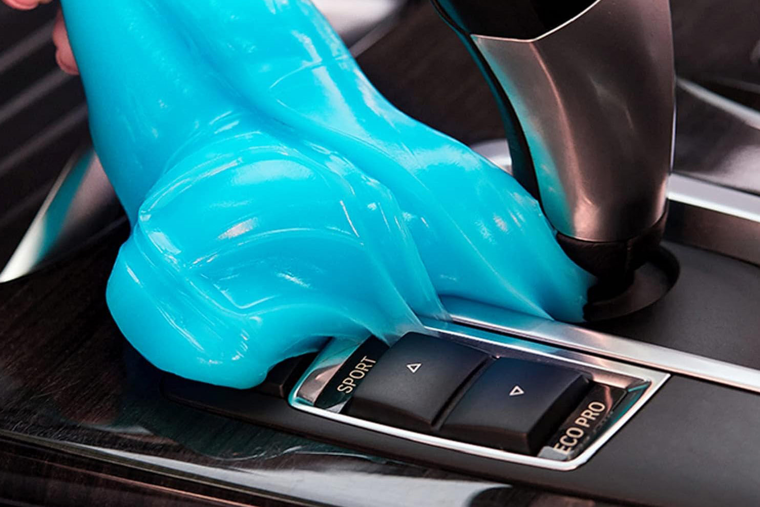 Blue cleaning putty being used on a desk and keyboard