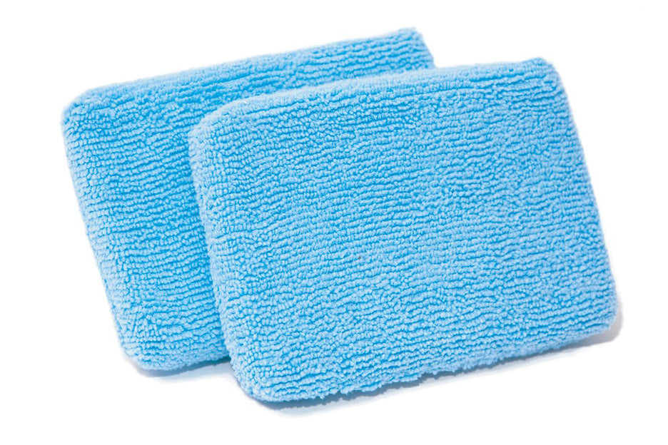 Two blue microfiber cleaning pads on a white background