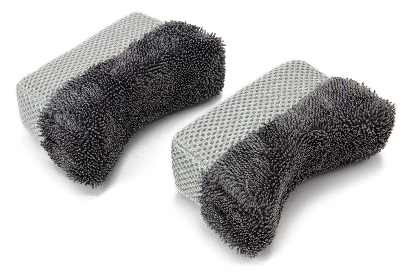 Two gray scrubber pads with textured surface on a white background