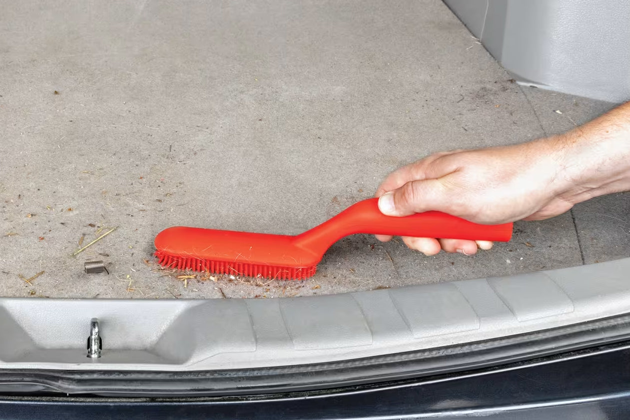Person cleaning car door with a red brush