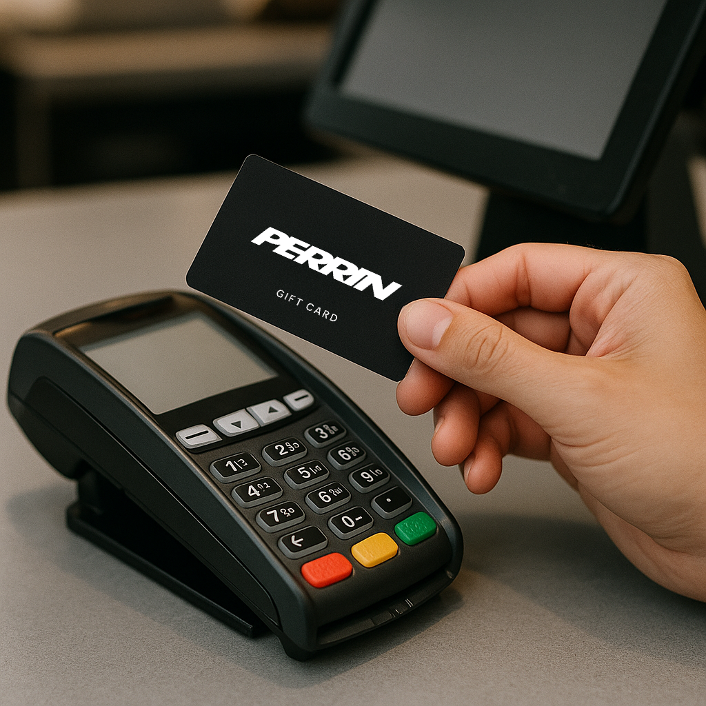 PERRIN gift card held above a card reader at a checkout counter, ideal for automotive enthusiasts.