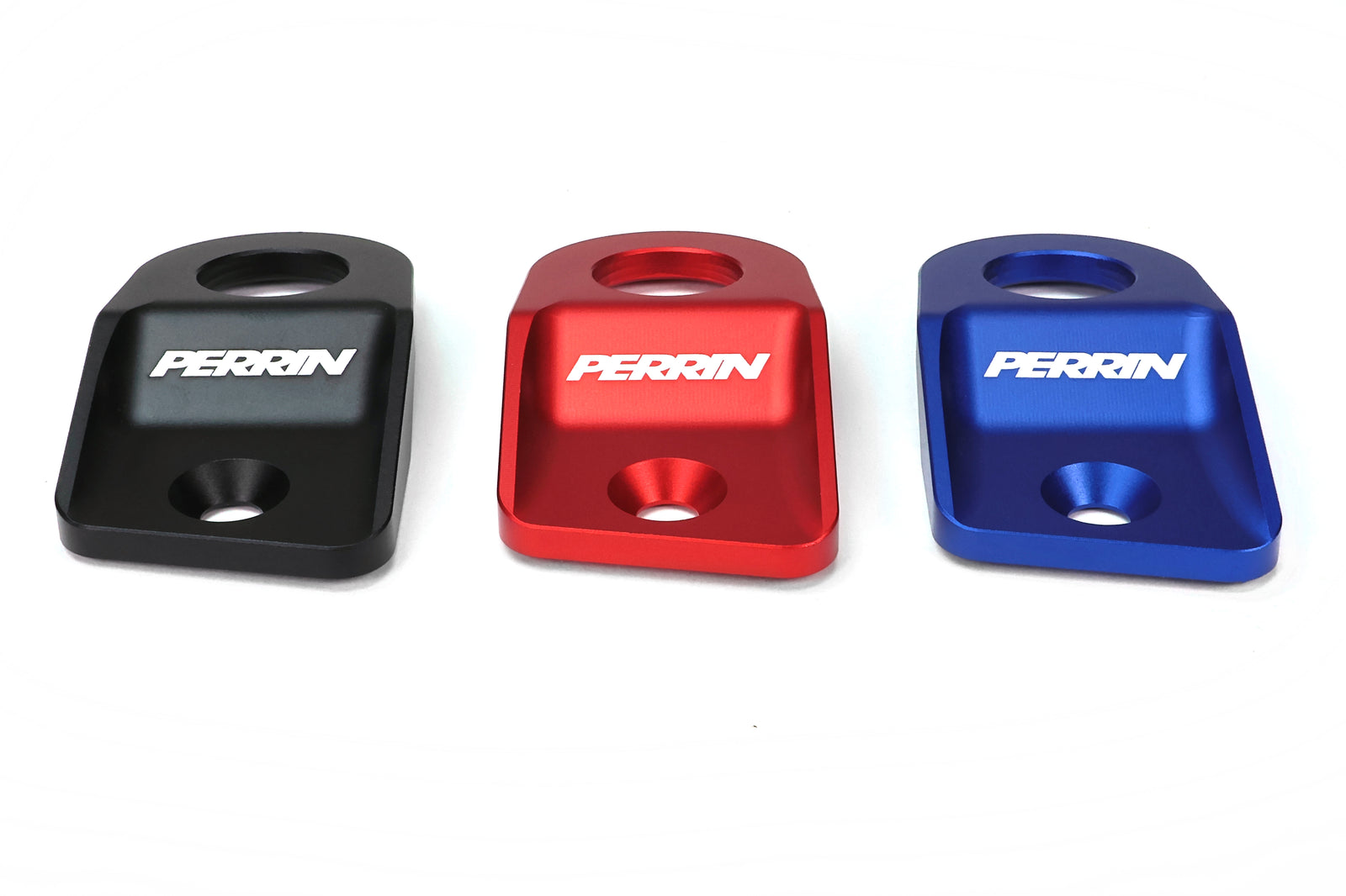 PERRIN radiator stays for 2015-2021 WRX, STI, Impreza, and Crosstrek in black, red, and blue finishes.