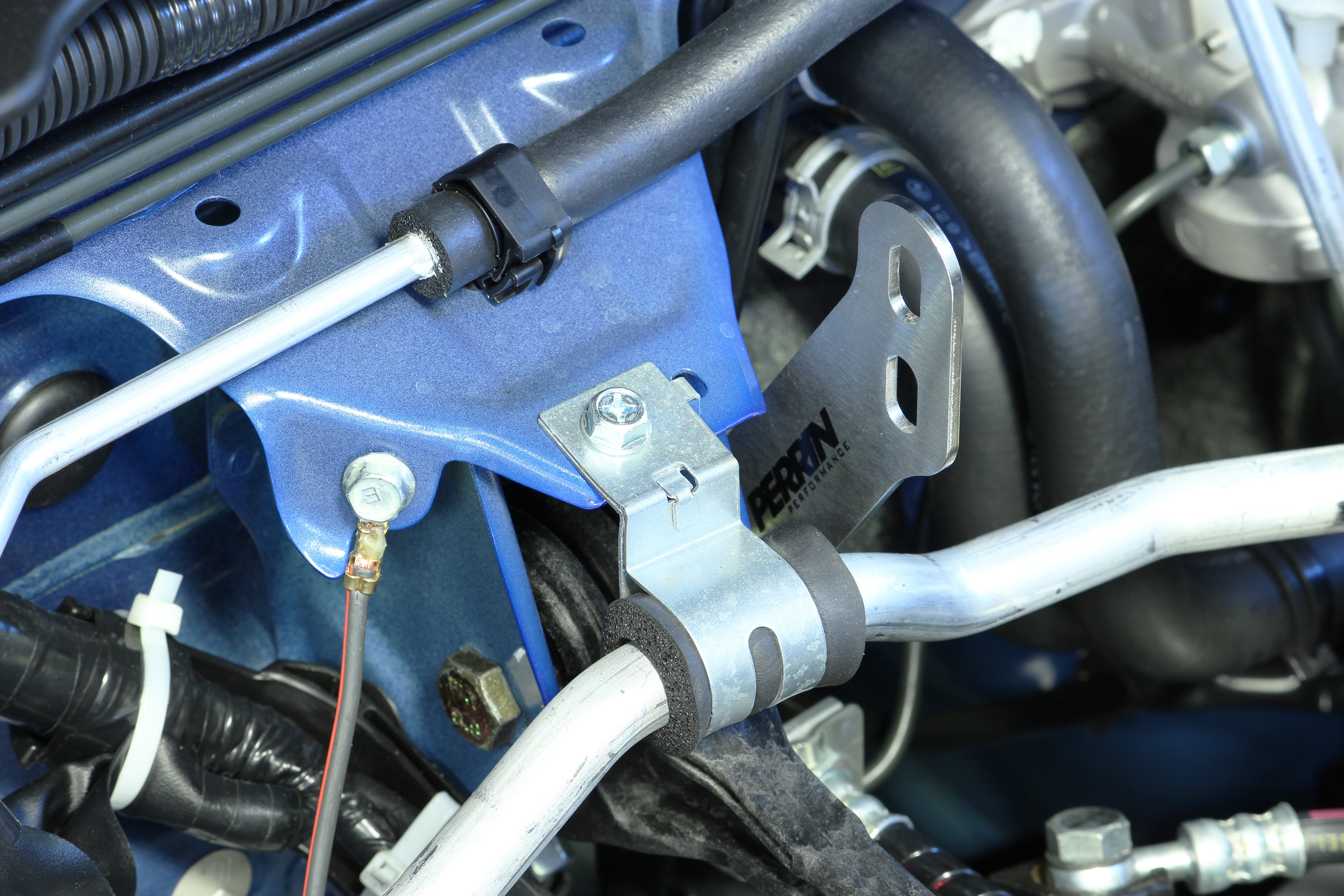 PERRIN Air Oil Separator FMIC mounting bracket installed on a 2002-2021 Subaru WRX/STI.