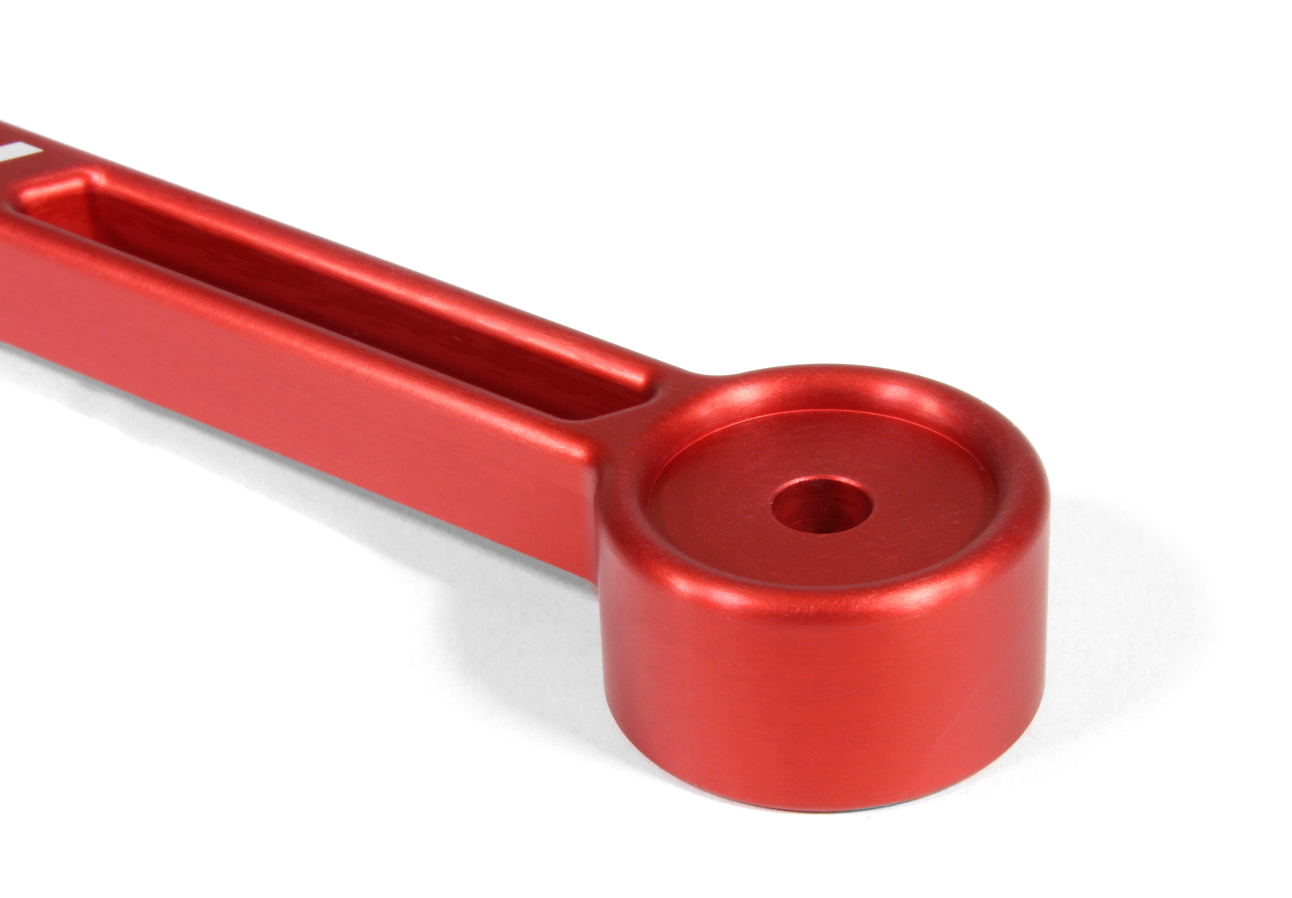 Red aluminum battery tie down designed for secure battery mounting in performance vehicles. Ideal for automotive enthusiasts.