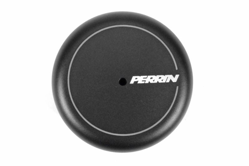 Black oil filter cover with a circular design and a central hole, featuring the Perrin logo in white.