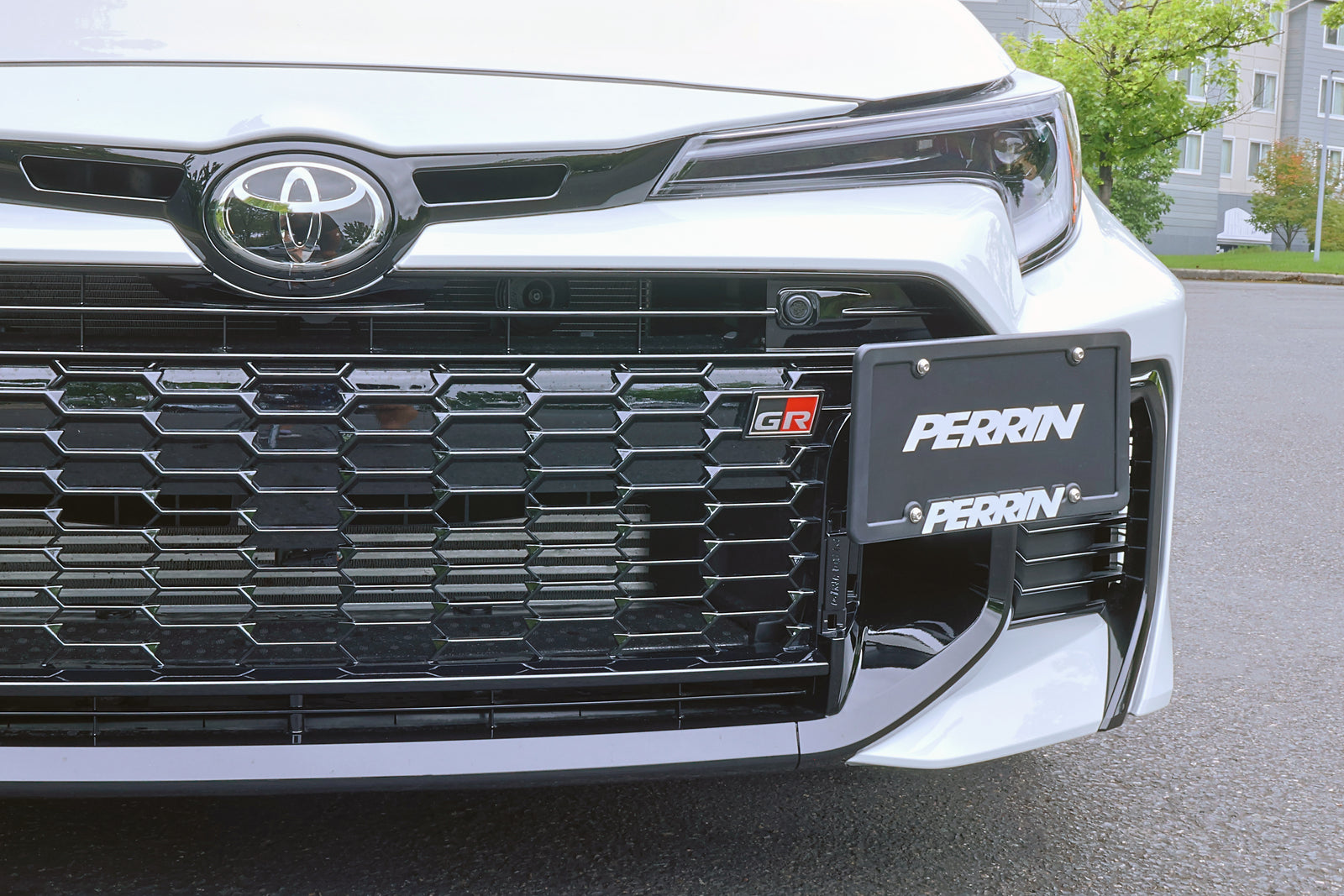 Detail view of PERRIN license plate bracket mounting stem and hardware on GR Corolla installation.
