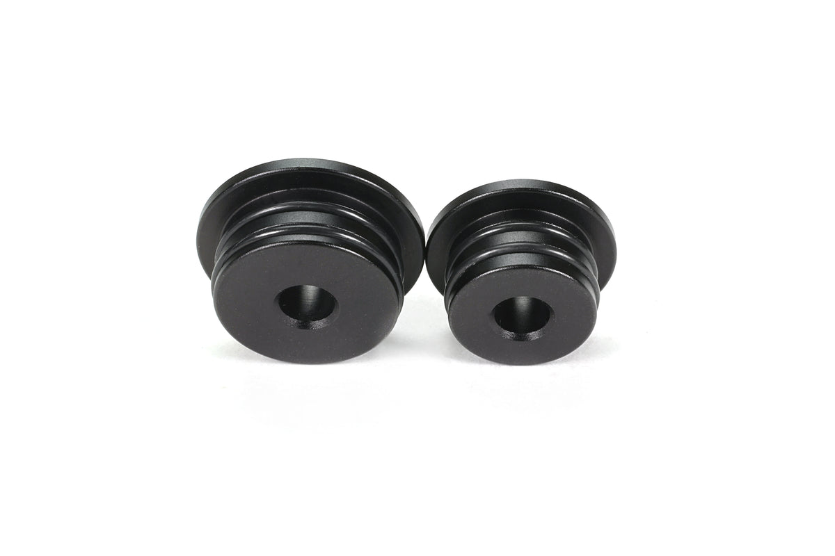 Two PERRIN GR Corolla Shifter Cable Bushings side by side on white background, black anodized aluminum with machined grooves.