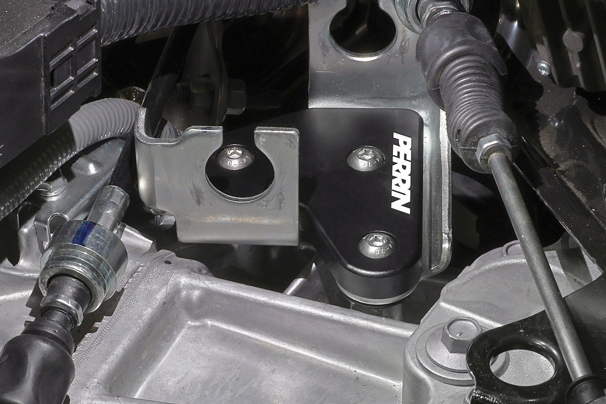 PERRIN GR Corolla Shifter Cable Bracket Lockdown with a black anodized installed on a Toyota GR Corolla.