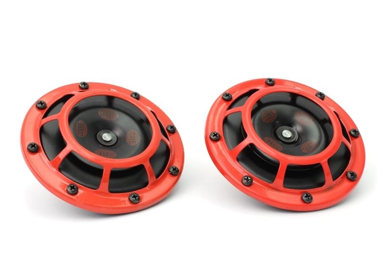 Hella Supertone Horns featuring a black center and red outer casing, designed for enhanced vehicle sound.