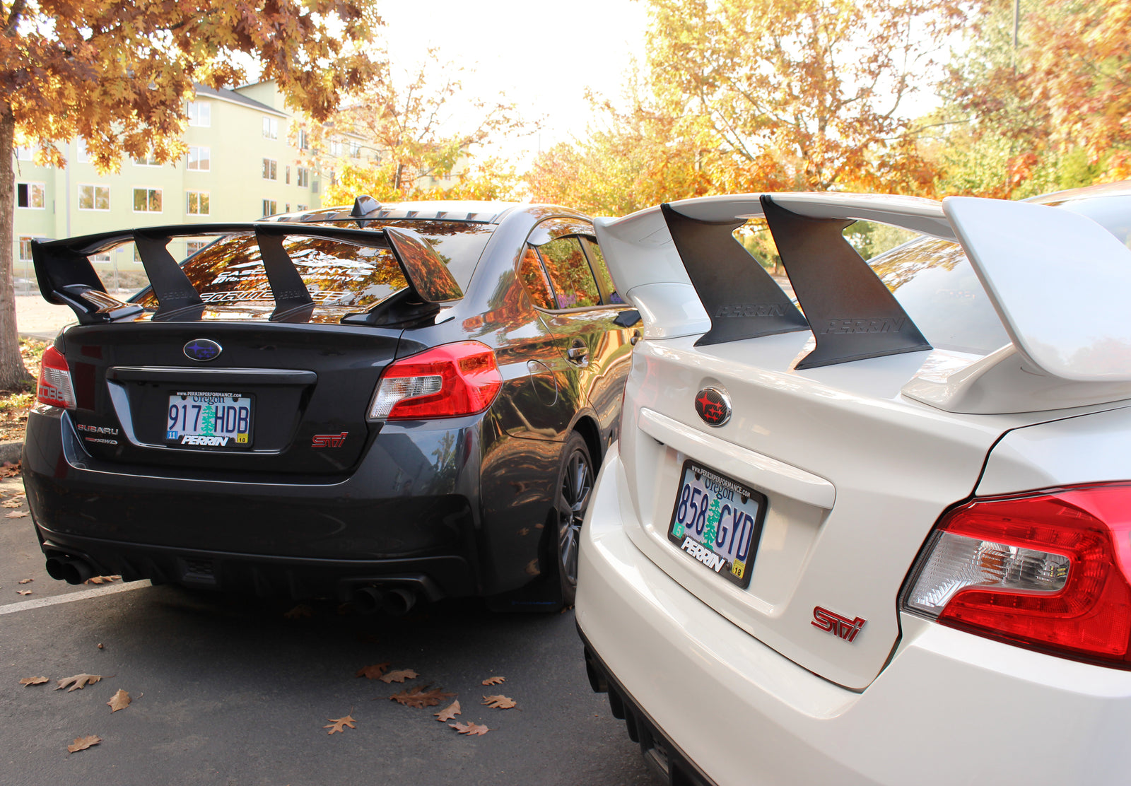 Wing stabilizers for 2015-2021 STI Sedans enhance aerodynamics and performance, showcased on two modified Subarus.