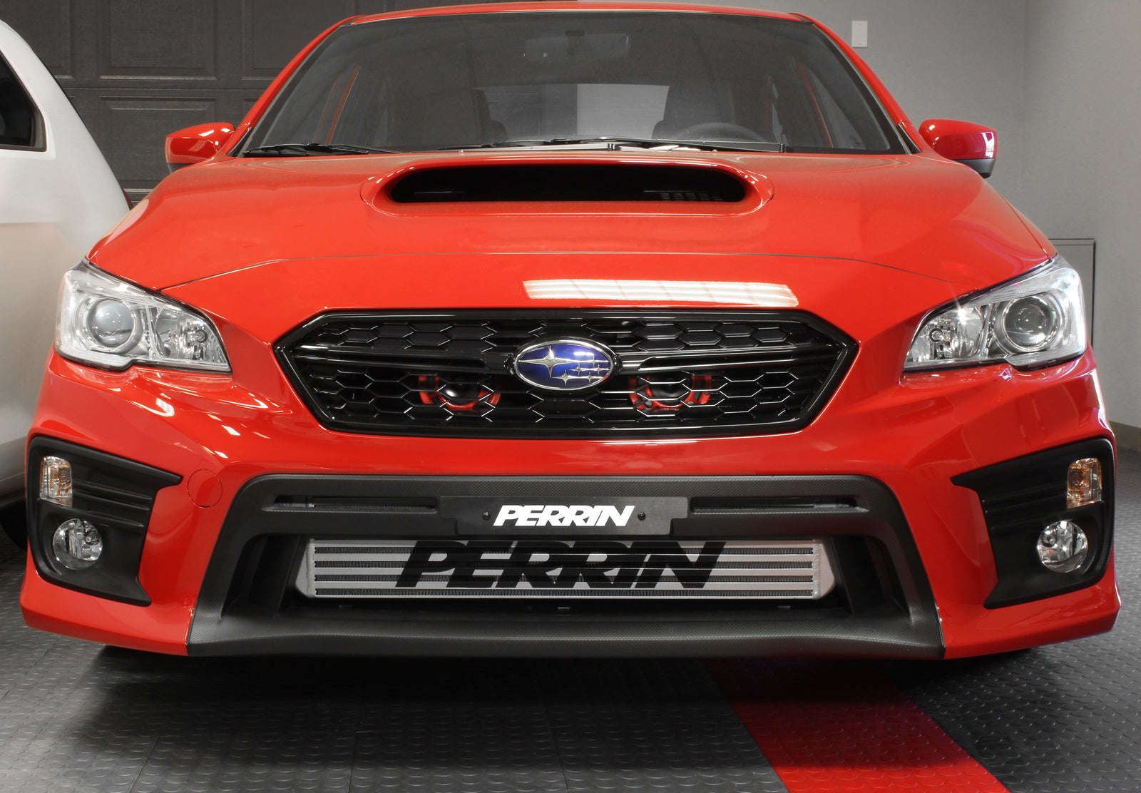 Horn bracket for 2015-2021 WRX, STI, Crosstrek, and Impreza installed on a red Subaru vehicle.