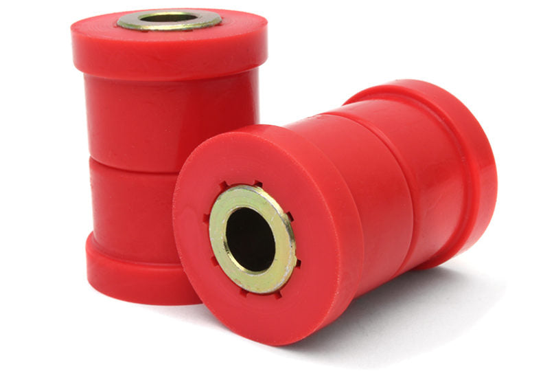 Red control arm bushings with metal inserts, designed for enhanced vehicle suspension performance and durability.